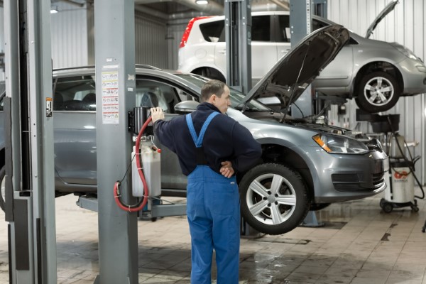 Batería de automóvil; mecanico cambiando una bateria